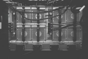 Black and white close-up of fans and cables on the back of a server
