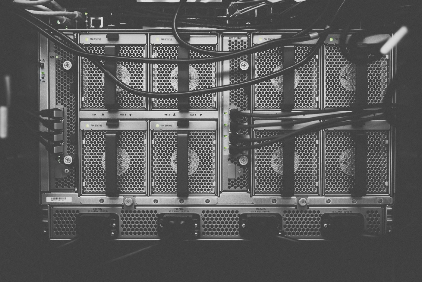 Black and white close-up of fans and cables on the back of a server